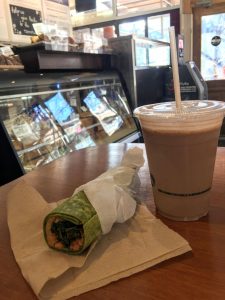 enjoying a smoothie and a wrap - just one of the best vegan breakfasts in whistler