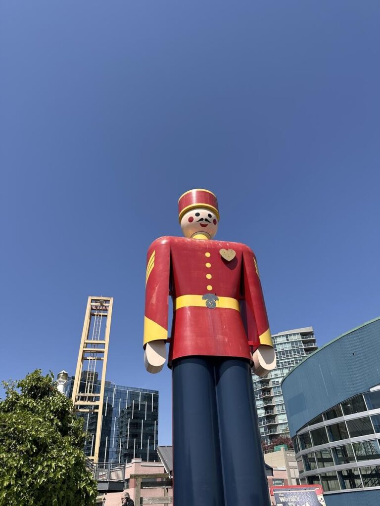 Giant red and blue tin soldier statue standing tall under a bright blue sky near New Westminster’s waterfront. This quirky local icon adds a fun photo stop right along the river.