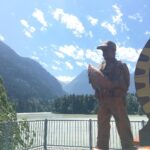 A large wooden statue of a fisherman holding a salmon stands on a lookout platform above the river, with dramatic mountain peaks in the distance. It&rsquo;s a fitting tribute to the area's heritage and a memorable spot when road-tripping through Hope, BC.