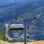 A chairlift rises over colorful alpine meadows with mountain bikes clipped to its side, stretching into the hills of Sun Peaks Resort. Just outside Kamloops, BC, this lift-accessed biking terrain makes exploring the high country effortless and exhilarating.