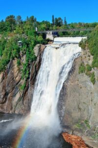 Montmorency Falls cascading into the river with a rainbow at the base, near Quebec City, Canada.