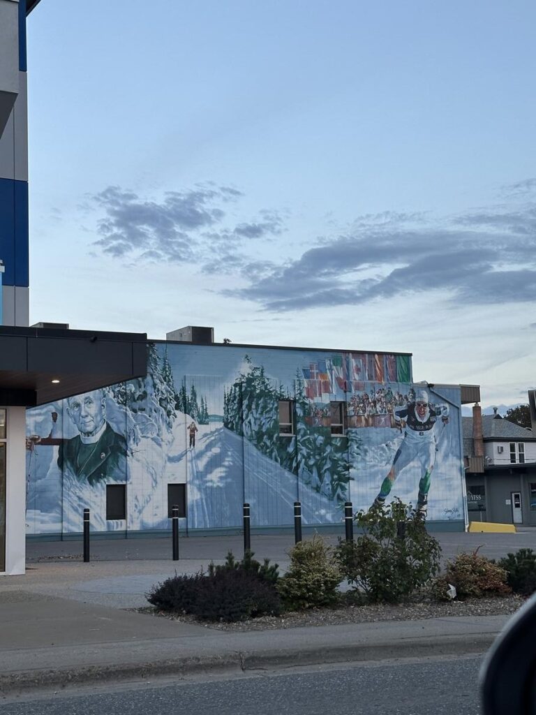 Mural titled &ldquo;Speed&rdquo; showing a winter sports scene with an athlete in motion, surrounded by snow-covered trees and cheering spectators.