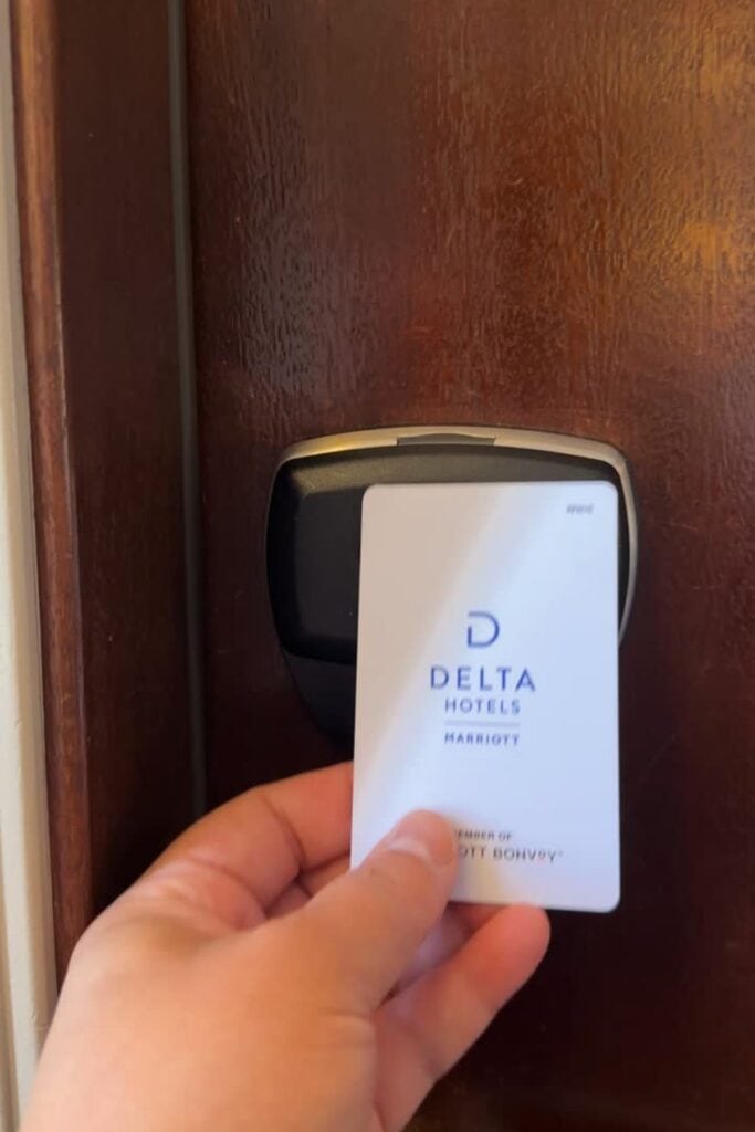 A hand holding a Delta Hotels by Marriott key card against the electronic door lock of a hotel room at the Delta Hotels Burnaby Conference Centre, Burnaby, BC.