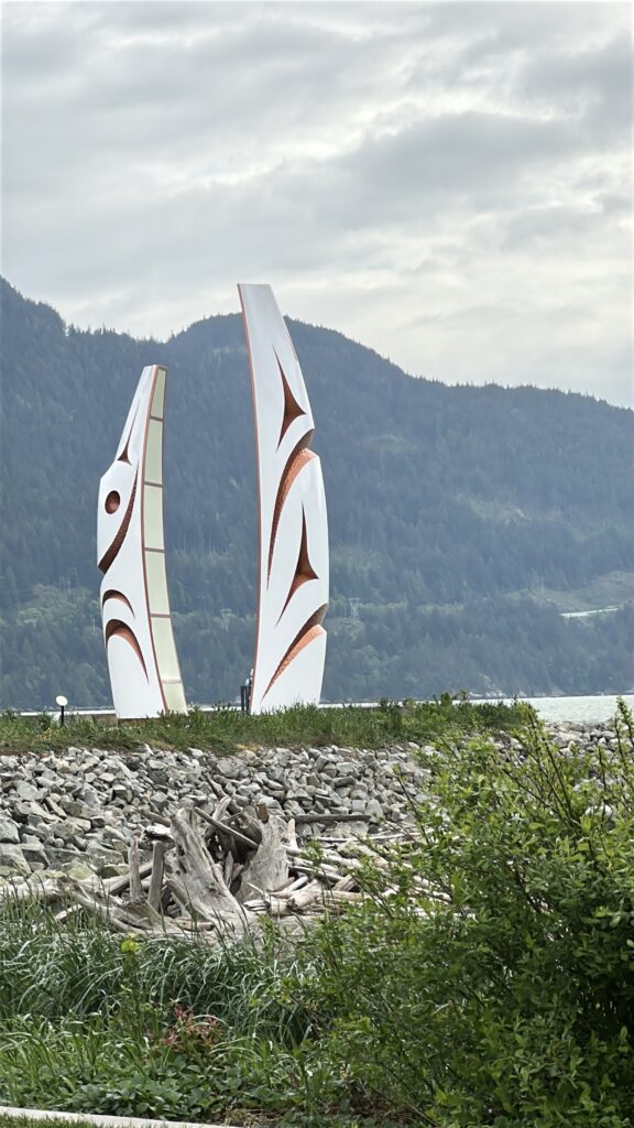 Large feather sculptures beside Howe Sound at Sp'&aacute;kw'us Feather Park in Squamish, BC, with shoreline habitat for slow travel and birdwatching.