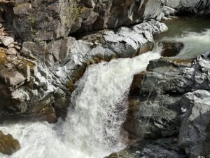 Close-up of water rushing over grey rock at Mamquam Falls, Squamish Canyon, Squamish BC, Canada. Photo by Tazim Damji.