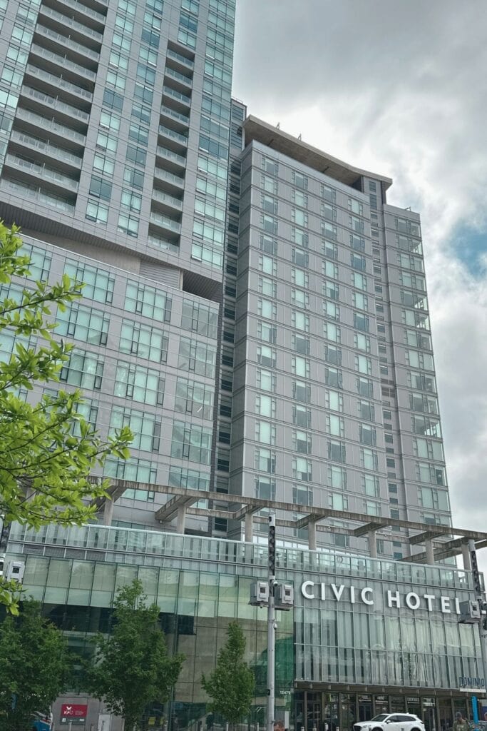 Exterior of the Civic Hotel Autograph Collection in Surrey City Centre BC with the Dominion Bar and Kitchen sign visible at street level