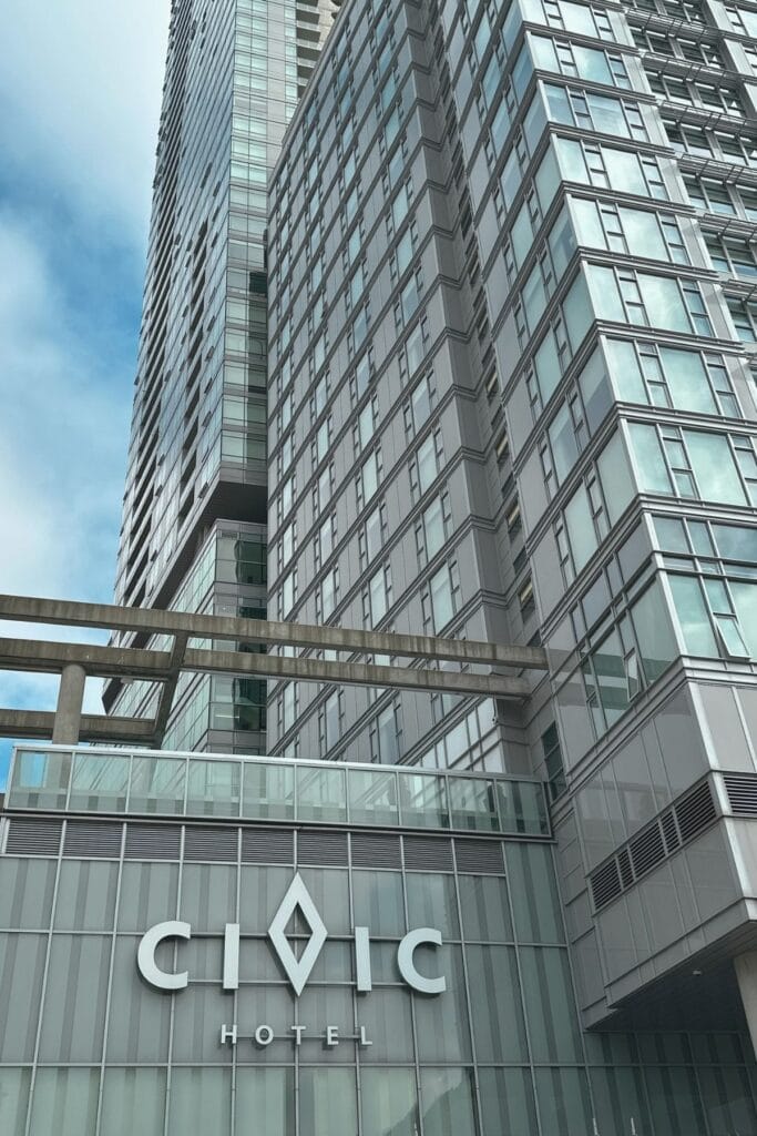 Close-up of the Civic Hotel sign on the glass and steel exterior of the hotel tower in Surrey City Centre BC