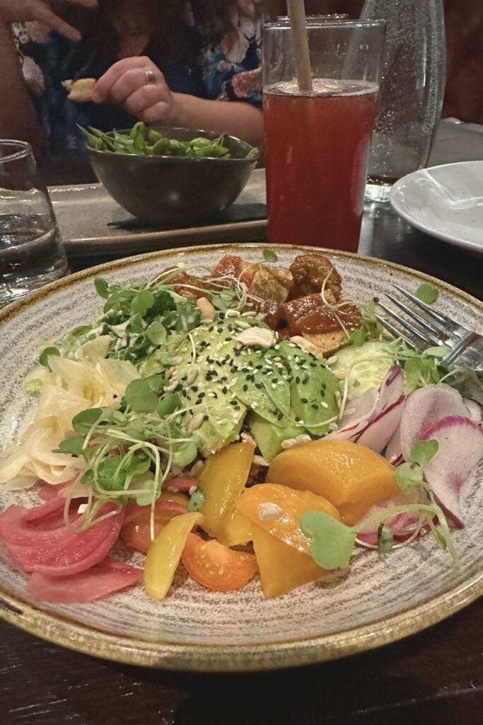 Colourful plant-based salad bowl with avocado, pickled vegetables, microgreens and sesame seeds at Dominion Bar and Kitchen Surrey BC