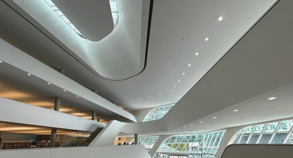 Interior of Surrey City Centre Library BC showing sweeping white curved ceilings, multiple open floors, and large curved glass windows