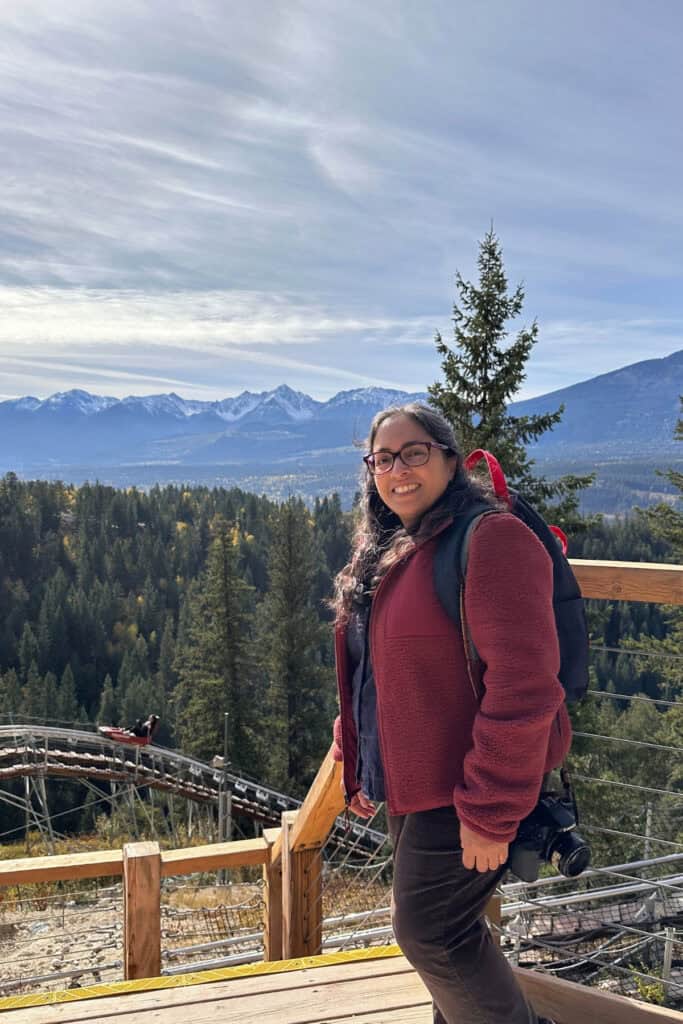 Woman hiking in the mountains with scenic views and snow-capped peaks.